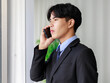 © Bangkok Click Studio - Young and handsome Asian businessman in black suit making call with smarphone