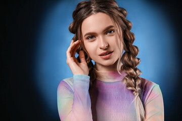 Wall Mural - Beautiful young woman with braided hair on dark background