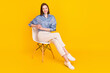 © deagreez - Photo of sweet adorable young lady dressed blue outfit sitting chair smiling isolated yellow color background
