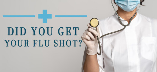 Wall Mural - Did you get your flu shot - concept of text on gray background. Nearby is a cropped view of doctor with stethoscope