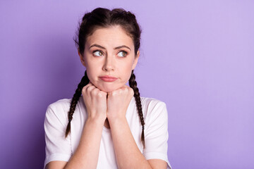 Canvas Print - Photo of dreamy upset young woman look empty space hold fists chin think isolated on purple color background