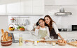 © Bangkok Click Studio - Asian Mother and daughter are happily hugging and bonding Inside the modern kitchen at home to make dessert..