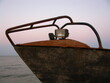 Stara zardzewiała łódź na brzegu morza wieczorem