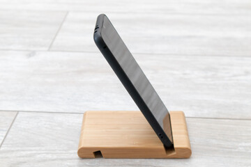 Black smartphone on a wooden stand