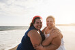 © DisobeyArt - Plus size women friends having fun on the beach with sunset in background - Soft focus on left female face