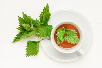 Herbal nettle tea in a  cup on the table. Top view