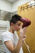 © Minet - Boy dries hair the hair dryer.