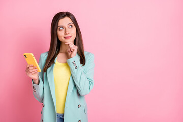 Wall Mural - photo of dreamy smart young lady look empty space hold hand chin phone comment isolated on pink colo