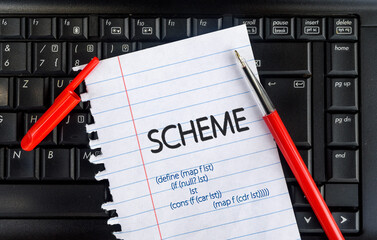 scheme programming language. word scheme on paper and laptop
