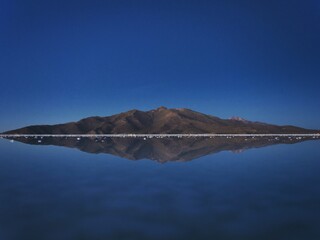 Wall Mural - Andes mountains sunrise panorama mirror reflection on Salar de Uyuni salt flat lake in Potosi Bolivia South America