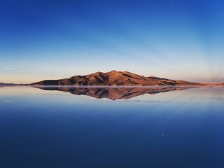 Wall Mural - Andes mountains sunrise panorama mirror reflection on Salar de Uyuni salt flat lake in Potosi Bolivia South America