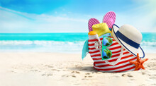 Summer Beach Bag And Accessories - Straw Hat, Flip Flops And Sunglasses On Sandy Beach And Azure Sea On Background