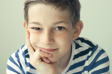 Portrait of handsome boy posing on white wall background