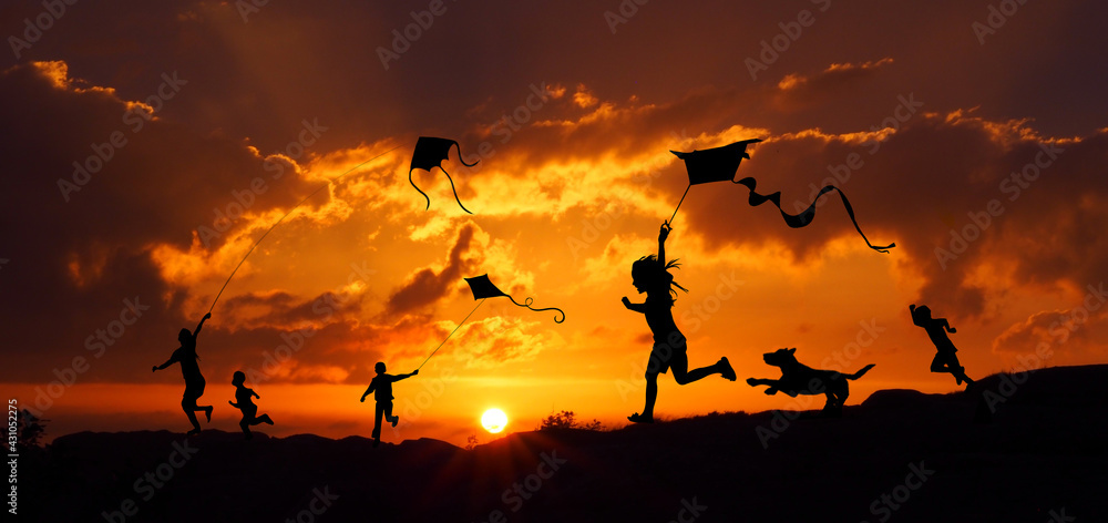 Sylwetki dzieci puszczających latawce o zachodzie słońca - obrazy, fototapety, plakaty 