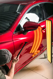 Fototapeta  - The technician removes dents on the car using the method without painting. PDR. Car body repair.