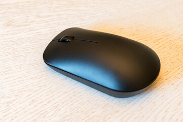 Close up of wireless computer mouse on white wooden background