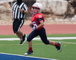 © Joe - Young athletic boy playing in a youth tackle football game
