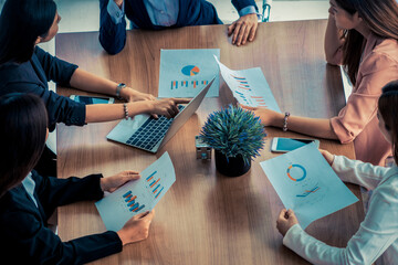 Businesswoman in group meeting discussion with other businesswomen colleagues in modern workplace office with laptop computer and documents on table. People corporate business working team concept.