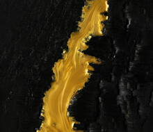 Vivid Contrast Of Black And Gold In Abstract Background Of Metallic Gold Paint Swirling Over Charred Black Ashes.
