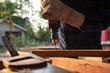 © somchai20162516 - Carpenter drills a hole with an electrical drill Carpenter doing his job in carpentry workshop.