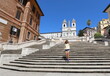 cute girl comes down the steps of PIAZZA DI SPAGNA in Rome in Italy and there are no other people during the lockdown caused by the coronavirus