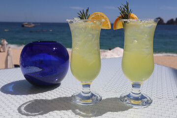 Canvas Print - Closeup of two margaritas with beach and ocean in the background at a luxury resort in Los Cabos