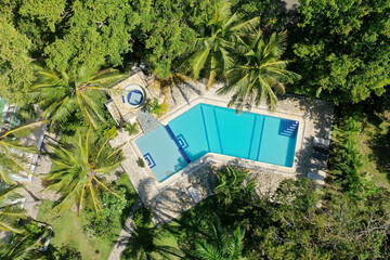 Wall Mural - Aerial shot of a pool in a resort area surrounded by greenery under the sunlight