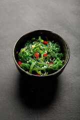 Wall Mural - Wakame seaweed with sesame and chilli on gray background. Asian food concept.