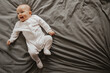 © Ananass - Beautiful cute baby lying and playing on the bed in the room, photo with daylight from the window