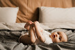© Ananass - Beautiful cute baby lying and playing on the bed in the room, photo with daylight from the window