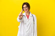 © luismolinero - Doctor woman isolated on yellow background showing and lifting a finger