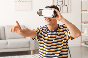 Wall Mural - Young man with virtual reality glasses at home