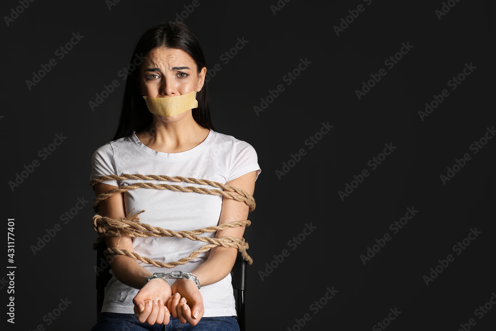 Female hostage on dark background