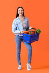 Sticker - Young woman with shopping basket on color background