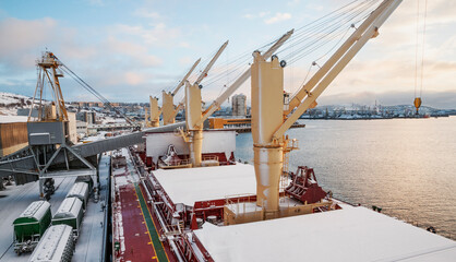 Dry cargo deck covered with a thin layer of snow
Bulk carrier at the mooring wall in the seaport, awaiting loading operations