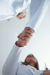 © DragonImages - Chief physician greeting new general practitional and shaking her hand, view from below