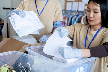 Sticker - Group of volunteers in gloves tearing paper over plastic containers