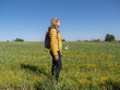 Attractive blonde female hiker wearing a backpack, posing on a sunny day in the fields of Toledo