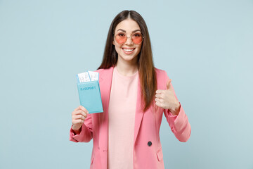 Wall Mural - Traveler tourist woman in pastel pink clothes glasses hold passport tickets show thumb up gesture isolated on blue background Passenger traveling abroad on weekends getaway Air flight journey concept