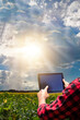 © Andre Nery - Farmer with tablet computer on the soy bean  plantation field countryside at sunset. Space for text.