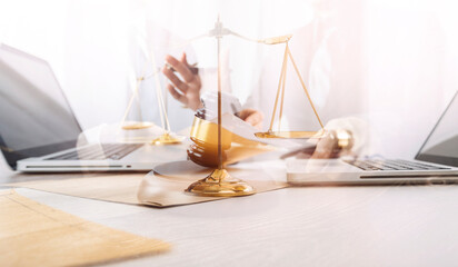 Justice and law concept.Male judge in a courtroom with the gavel, working with, computer and docking keyboard, eyeglasses, on table in morning light