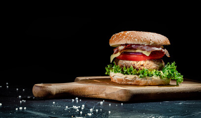 Delicious tasty burger with beef cutlet on the dark background