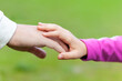 © nievesmares - Padre e hija dándose la mano con un fondo de naturaleza, paternidad, concepto de colaboración, unión y apoyo