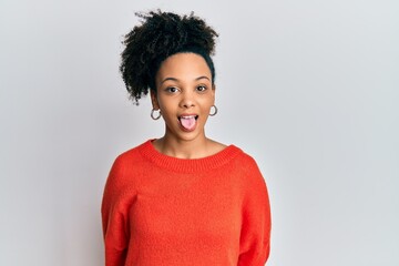 Wall Mural - Young african american girl wearing casual clothes sticking tongue out happy with funny expression. emotion concept.