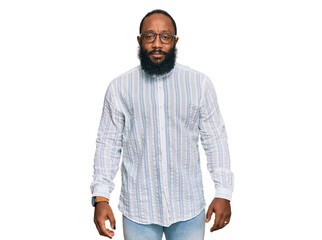 Young african american man wearing business shirt and glasses with serious expression on face. simple and natural looking at the camera.