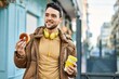 © Krakenimages.com - Young hispanic man having breakfast using headphones at the city.