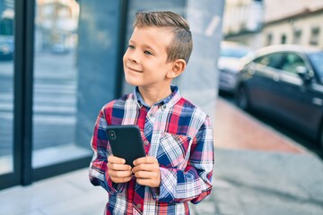 Poster - Adorable caucasian boy smiling happy using smartphone at the city.