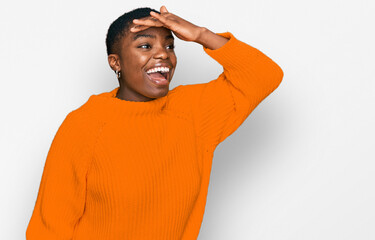 Canvas Print - Young african american woman wearing casual clothes very happy and smiling looking far away with hand over head. searching concept.