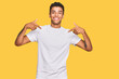 © Krakenimages.com - Young handsome african american man wearing casual white tshirt looking confident with smile on face, pointing oneself with fingers proud and happy.