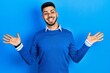 © Krakenimages.com - Young hispanic man with beard wearing casual blue sweater celebrating crazy and amazed for success with arms raised and open eyes screaming excited. winner concept